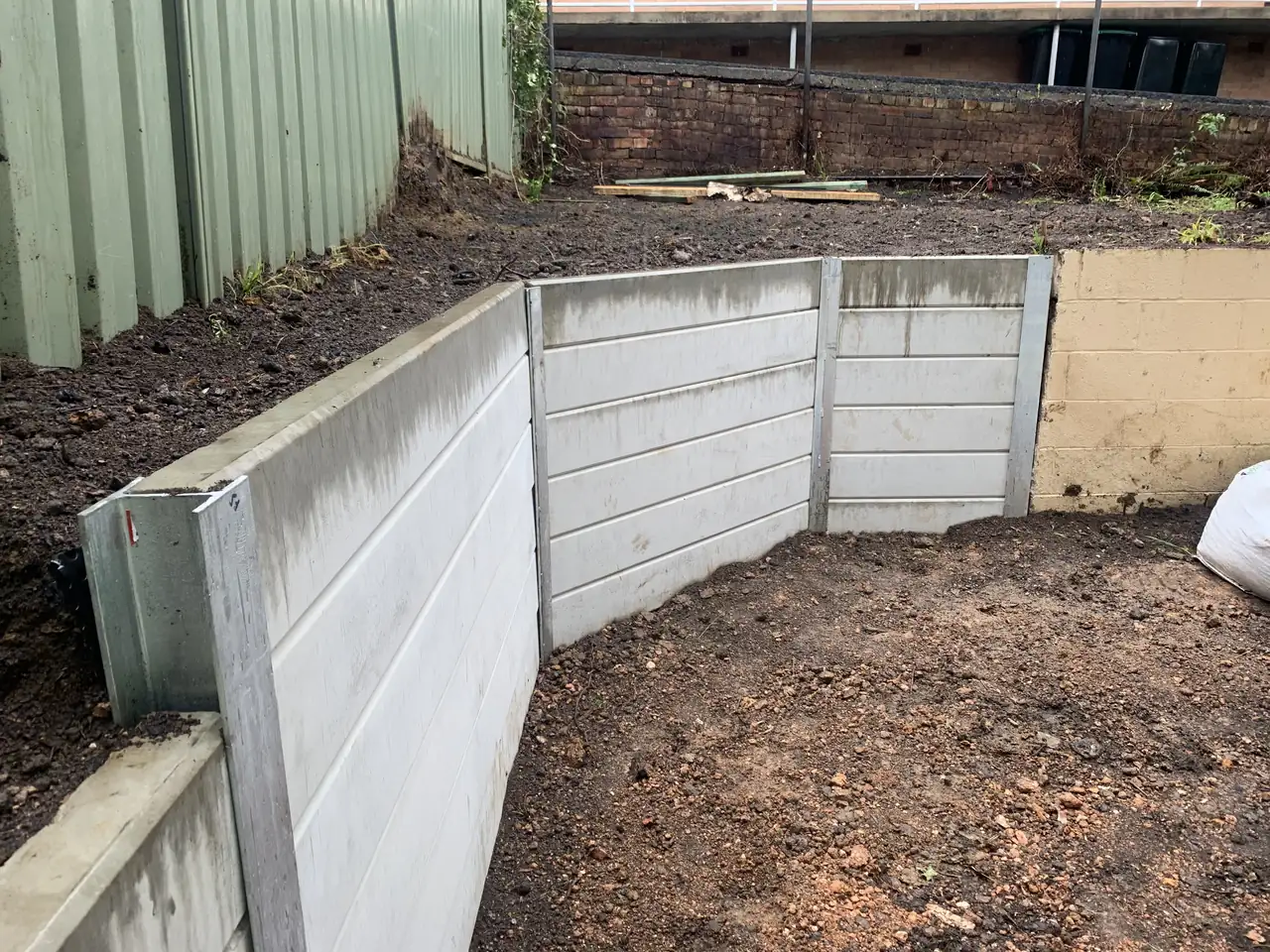 White concrete sleeper walls forming a raised garden corner