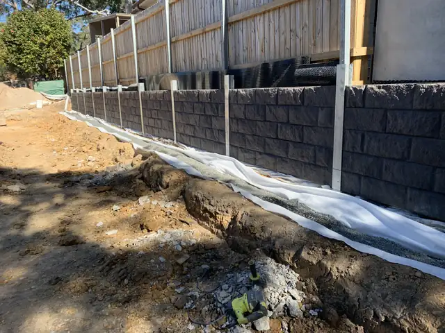 Membrane and drainage behind a new concrete sleeper wall before backfill